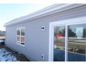 Exterior view of gray vinyl siding, large window, and sliding glass door to back yard at 10126 Camp Creek Way, Indianapolis, IN 46229