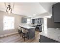 Bright kitchen featuring grey cabinetry, quartz countertops and seating for three at the counter at 10353 Liverpool Way, Indianapolis, IN 46236