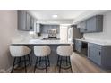 Bright kitchen featuring grey cabinetry, stainless appliances and counter seating for three at 10353 Liverpool Way, Indianapolis, IN 46236