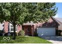 Lovely red brick home with mature tree in the front yard and two-car garage at 10891 Santa Anita Ct, Carmel, IN 46280