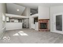 Spacious living room with brick fireplace and an open floor plan flowing into the kitchen at 10891 Santa Anita Ct, Carmel, IN 46280