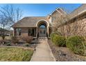 Inviting walkway leads to the brick facade home featuring an arched entryway and detailed double doors at 1110 Butternut Dr, Columbus, IN 47201
