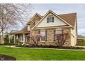 Beautiful two-story home featuring stone accents, a covered porch, and blossoming landscape at 11686 Belle Plaine Blvd, Fishers, IN 46037