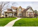 Inviting two-story home with stone facade, covered porch, and lush green lawn at 11686 Belle Plaine Blvd, Fishers, IN 46037