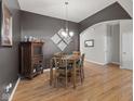 Dining room with dark grey walls, wooden table, and chair set underneath a modern light fixture at 12610 Broadmoor N Ct, Fishers, IN 46037