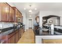 Modern kitchen featuring stainless steel appliances, dark countertops and rich wood cabinetry at 12610 Broadmoor N Ct, Fishers, IN 46037
