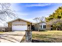 A single-story home featuring a stone facade, attached garage, and a well-maintained front yard at 12930 River Grove Dr, Columbus, IN 47203
