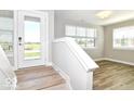 Light-filled entryway featuring wood-look floors, staircase, and a glass front door at 12974 Pettigru Dr, Carmel, IN 46032