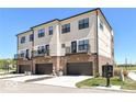Three-story townhouses with drive-in garages and second story patios on a clear day at 12974 Pettigru Dr, Carmel, IN 46032