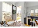 A welcoming foyer with a stylish chair, open door, and a view of the living area at 13071 Pennington Rd, Fishers, IN 46037