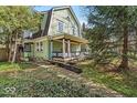 Charming two-story home with a gambrel roof, inviting front porch with swing, and brick chimney at 140 E 44Th St, Indianapolis, IN 46205