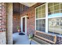 Inviting porch features brick accents, a cozy bench, and charming outdoor decor at 14347 Camelot House Way, Fishers, IN 46037