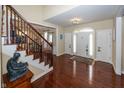 Inviting home foyer featuring hardwood floors, a staircase, and a decorative light fixture at 14375 Alderbrook Trl, Carmel, IN 46033