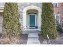 Charming front entrance with stone archway, a blue front door, and manicured greenery at 14375 Alderbrook Trl, Carmel, IN 46033