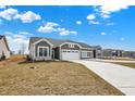 Charming single-story house showcasing a grey exterior, a two-car garage, and a paved driveway at 1603 Clover Crossing Dr # 1A, Greenfield, IN 46140