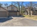 Home exterior featuring a driveway, attached garage, and mature trees at 2215 Van Ness Pl, Indianapolis, IN 46240