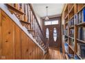 Inviting entryway features wood-paneled walls, staircase, and stylish front door with adjacent bookshelves at 300 S Market St, Thorntown, IN 46071