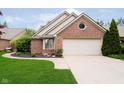 Front exterior view of a brick home with an attached two-car garage and a well maintained lawn at 3034 Tiffany Ct, Carmel, IN 46033