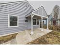 Close-up of a cozy entrance showcasing gray siding and a covered porch with support columns at 3918 Columbus Ave, Anderson, IN 46013