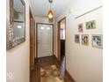 Inviting hallway with a decorative gallery wall, stylish floors and a front door at 4238 Vestry Ct, Indianapolis, IN 46237