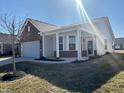 Inviting home exterior featuring a brick accent, covered porch and well-manicured yard at 4889 Lilium Dr, Plainfield, IN 46168