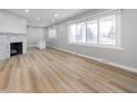 Inviting living room with a decorative fireplace, light wood flooring, and large, bright windows at 5683 Boy Scout Rd, Lawrence, IN 46226
