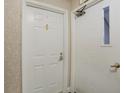 View of a white entry door and an adjacent door with a small window and hardware at 6525 Emerald Hill Ct # 207, Indianapolis, IN 46237