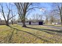 Inviting single-story home with a well-manicured lawn, gray brick facade, and attached garage on a sunny day at 6603 Iona Rd, Indianapolis, IN 46203