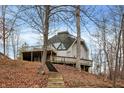 Exterior view of a unique dome home set on a hillside with an elevated deck and stairway at 6655 Gopher Dr, Nineveh, IN 46164