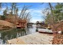Waterfront view featuring a dock, wooden piers, and a tranquil lake setting under a blue sky at 6655 Gopher Dr, Nineveh, IN 46164