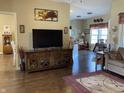 Open concept living area with a large TV, hardwood floors, and seamless flow to adjacent rooms at 1002 Plummer Rd, Martinsville, IN 46151
