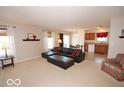 Open-concept living area with a cozy sofa, large windows, and access to the kitchen and dining area for easy living at 11026 Cool Winds Way, Fishers, IN 46037