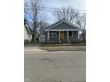 A cozy home with a bright yellow door, inviting front porch, and detached garage at 1237 E 29Th St, Anderson, IN 46016