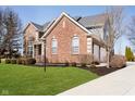 Charming two-story brick house featuring a well-kept lawn, neat landscaping, and a side entry garage at 12959 Reedy Ct, Carmel, IN 46032