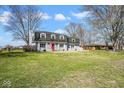 Charming home with a red front door, grey brick, shutters, and a well-maintained lawn at 1310 Bowman Dr, Greenfield, IN 46140