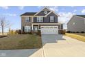 Charming two-story home with stone and siding, a well-manicured lawn, and a two-car garage at 13615 Moorcroft Dr, Fishers, IN 46037