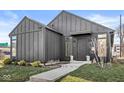 Modern home featuring dark siding, manicured front yard, and concrete steps to the front door at 1510 Columbia Ave, Indianapolis, IN 46202