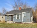 Cozy single-story home with gray siding and a classic brick chimney, situated in a quiet neighborhood at 1953 N Linwood Ave, Indianapolis, IN 46218