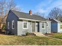 Classic single-story home with gray siding and a brick chimney, offering a traditional and inviting facade at 1953 N Linwood Ave, Indianapolis, IN 46218