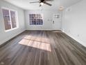 Bright living room featuring modern hardwood floors, a ceiling fan, and a large window for natural light at 2365 Grand Fir Dr, Greenwood, IN 46143