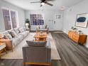 Bright living room features modern furniture, hardwood floors, a ceiling fan, and a large window for natural light at 2365 Grand Fir Dr, Greenwood, IN 46143