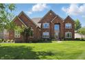 Charming brick home featuring manicured lawn and tasteful landscaping at 2750 Joshua Dr, Carmel, IN 46033
