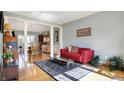 Bright living room with hardwood floors, open to dining room, and a stylish red sofa at 2750 Joshua Dr, Carmel, IN 46033