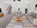 Bright living room featuring modern furnishings, neutral tones, and a cozy carpet, with stairs leading to the upper level at 3153 Underwood Dr, Whiteland, IN 46184