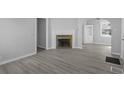 Spacious living room featuring a decorative fireplace, laminate flooring, and neutral paint tones at 3701 N Temple Ave, Indianapolis, IN 46218