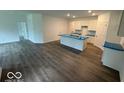 Open-concept kitchen and living area featuring a large island with white cabinets and laminate wood flooring at 3912 Bamboo Branch Dr, Clayton, IN 46118