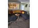 Cozy living room features a plush gray sectional, carpeted floors, and an open view to the kitchen at 4125 Dequincy St, Indianapolis, IN 46226