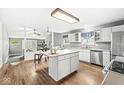 Bright kitchen featuring an island, stainless steel appliances, hardwood floors, and adjacent dining area at 5014 Melbourne Rd, Indianapolis, IN 46228