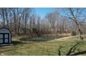 A scenic view of a serene pond with a fountain, surrounded by lush greenery and mature trees at 5014 Melbourne Rd, Indianapolis, IN 46228