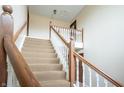 Carpeted staircase with wooden banister and white spindles at 505 W Hunters Dr # D, Carmel, IN 46032